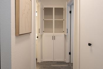 a hallway with white cabinets and a picture on the wall